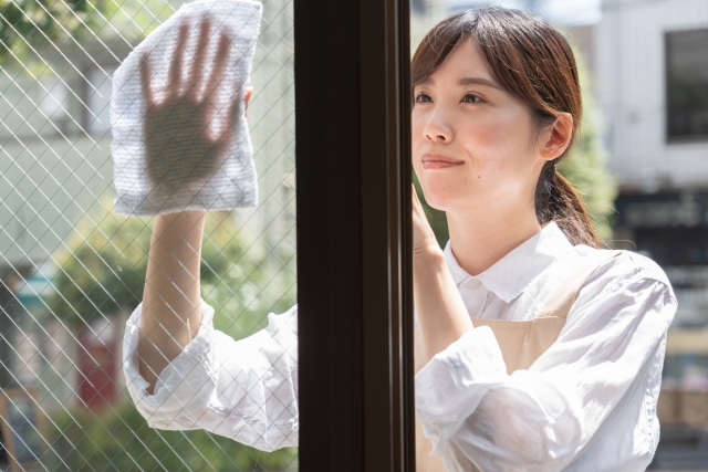 窓を掃除する女性
