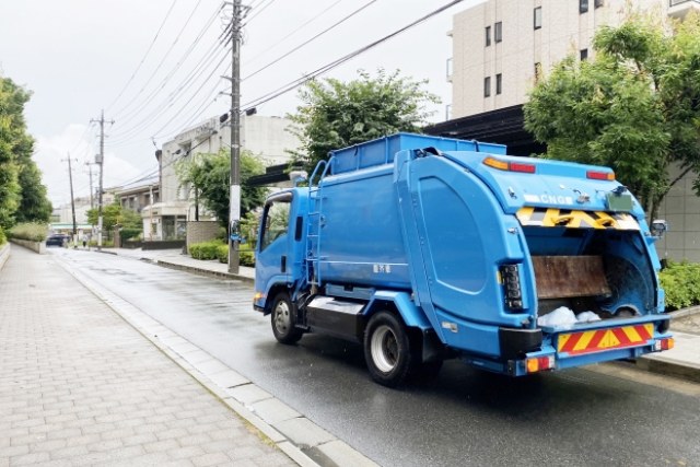 青いゴミ収集車が走る様子